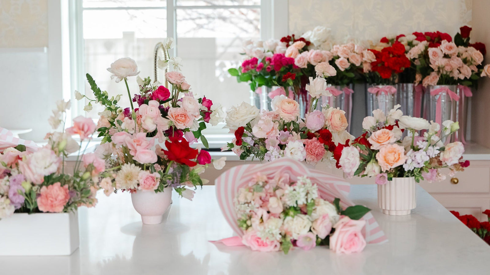 Bouquets of flowers on a table with a window in the background