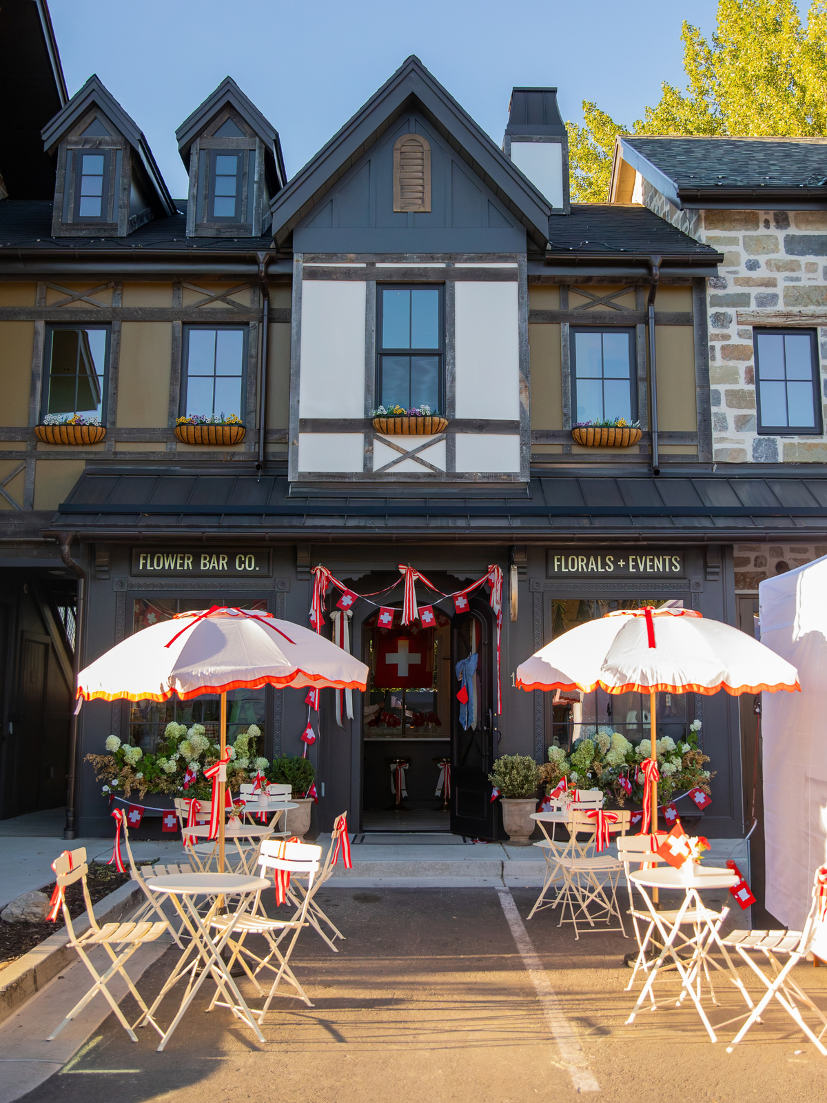 Flower Bar Co. flower shop Midway location decorated for Swiss Days with Swiss flags and seasonal florals.
