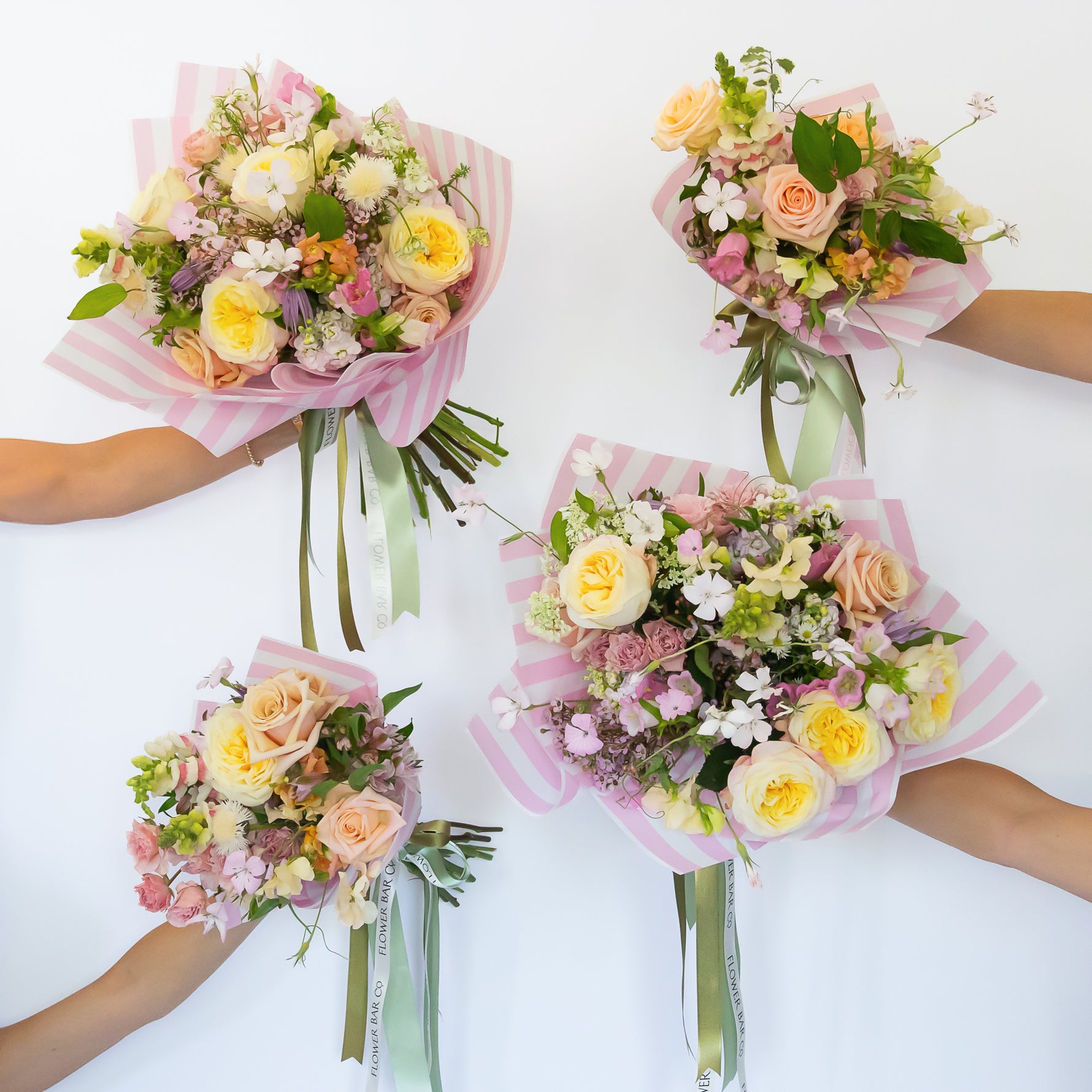 Four pastel flower bouquets wrapped in pink striped paper