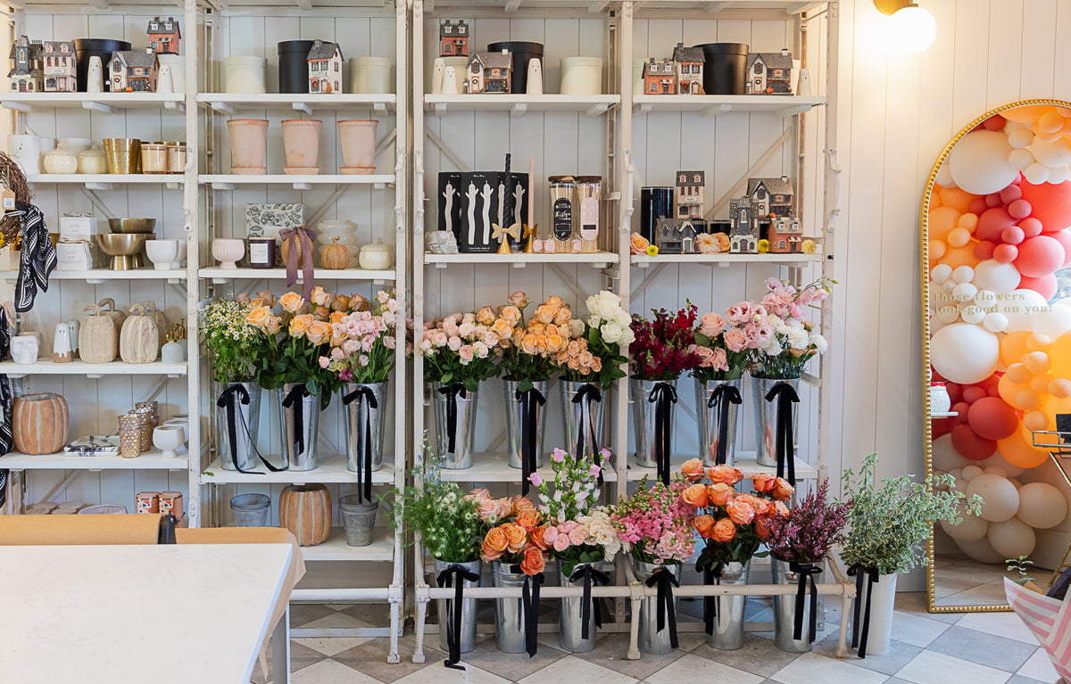 Colorful, fresh flower buckets in a single-stem flower bar, fall candles, autumn decorative vases, and other fall home decor items.