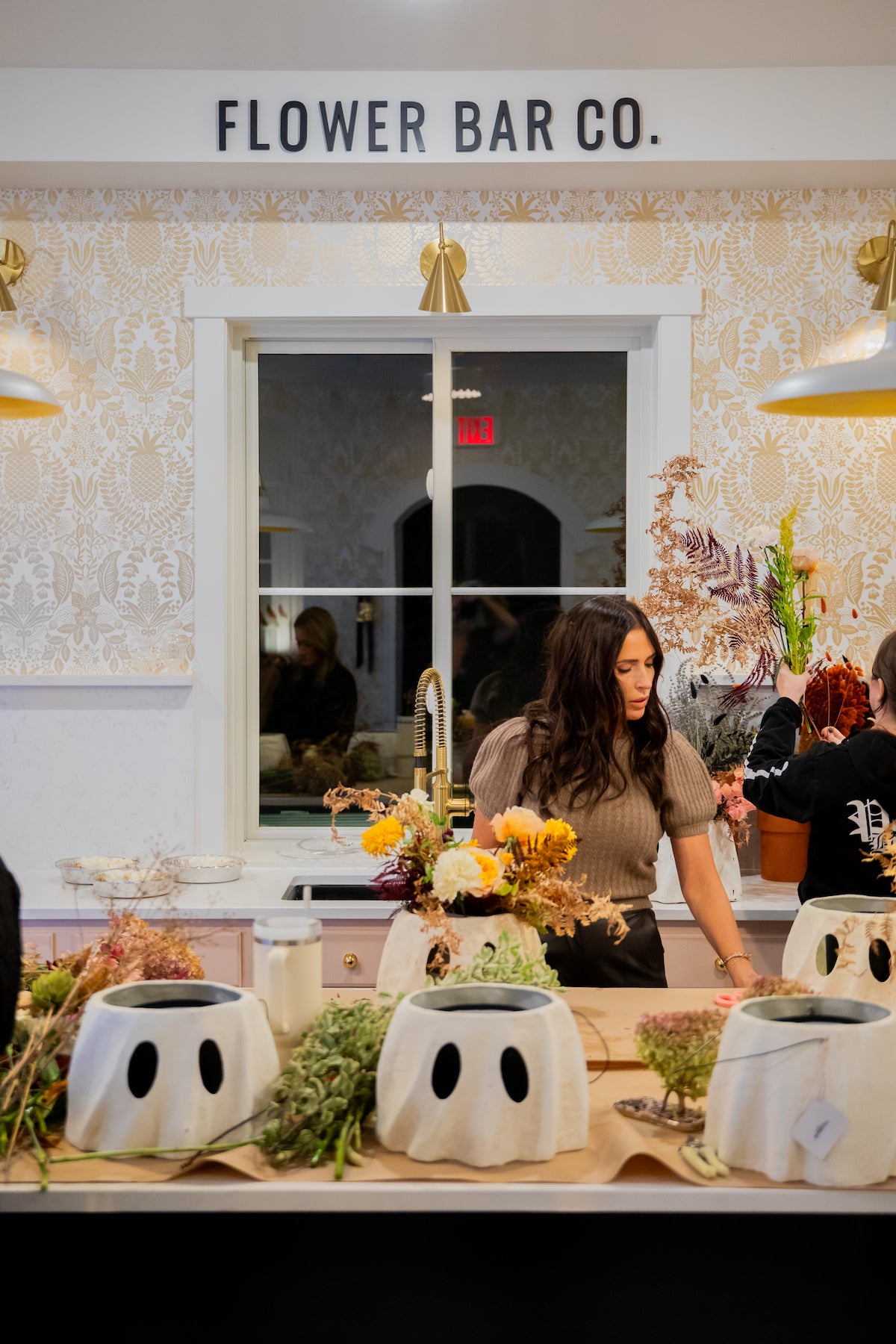 Flower Bar Co. owner and florist Shawn Bailey instructs a fall floral arranging workshop using Bethany Lowe ghost bucket planters. 