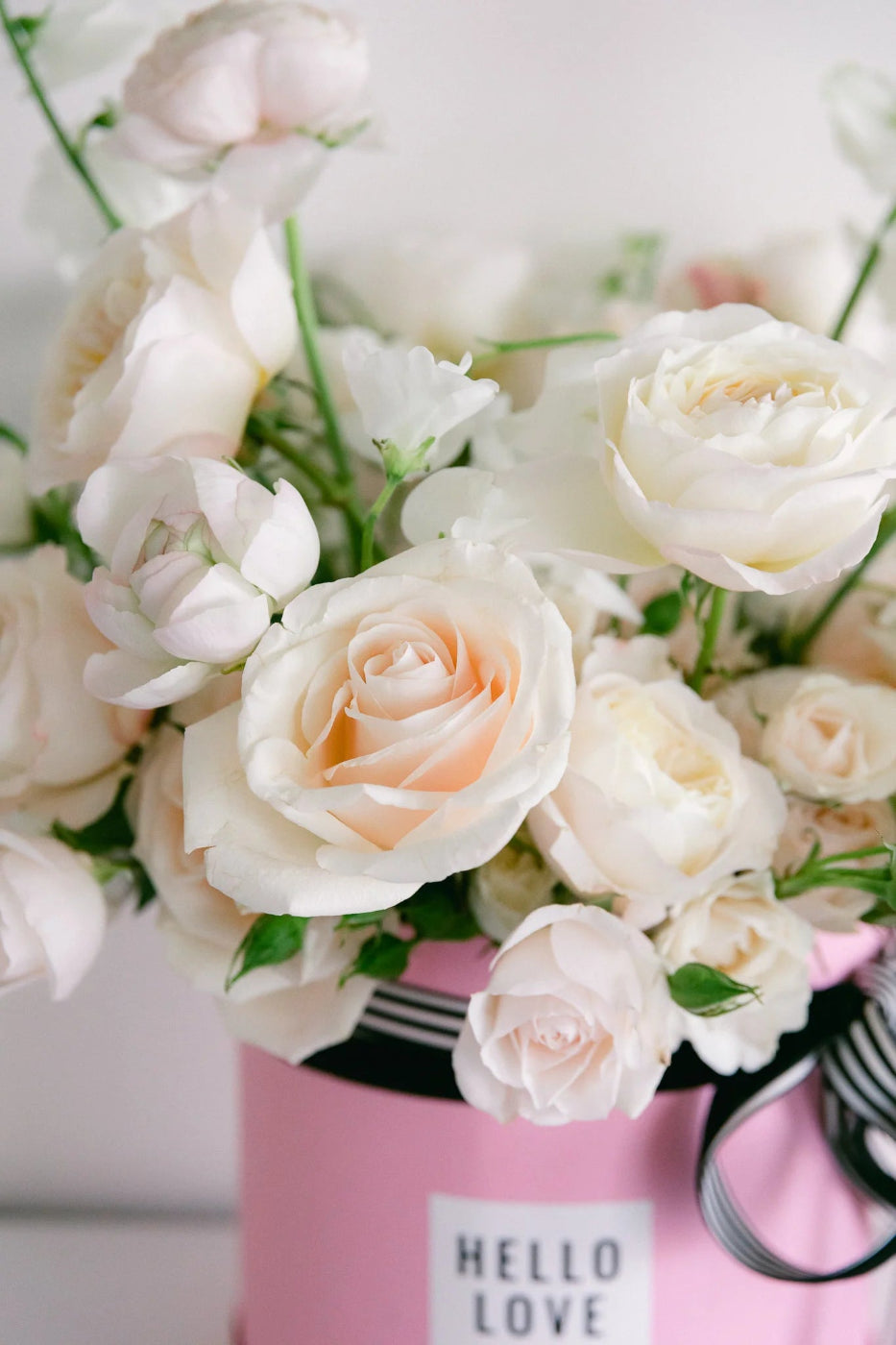 white floral arrangement in pink gift box